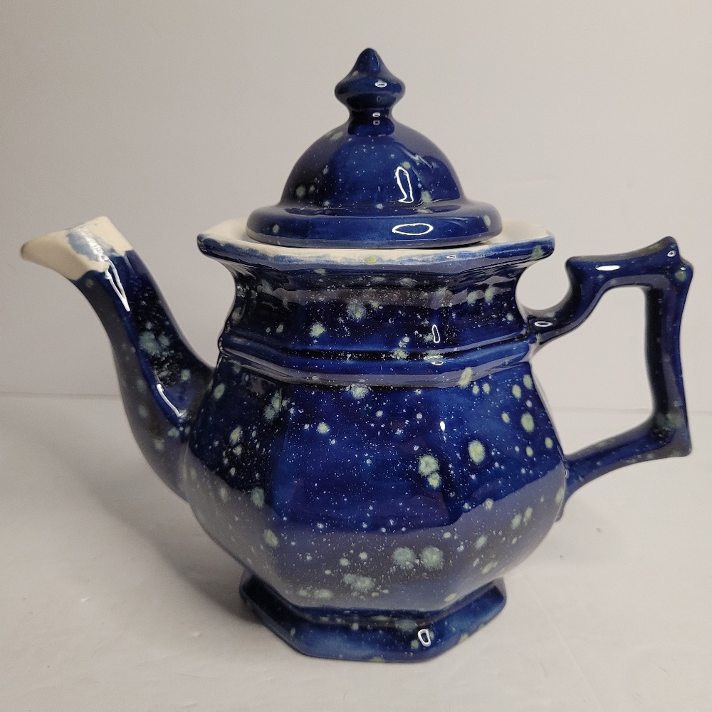 A blue and white speckled teapot. 271